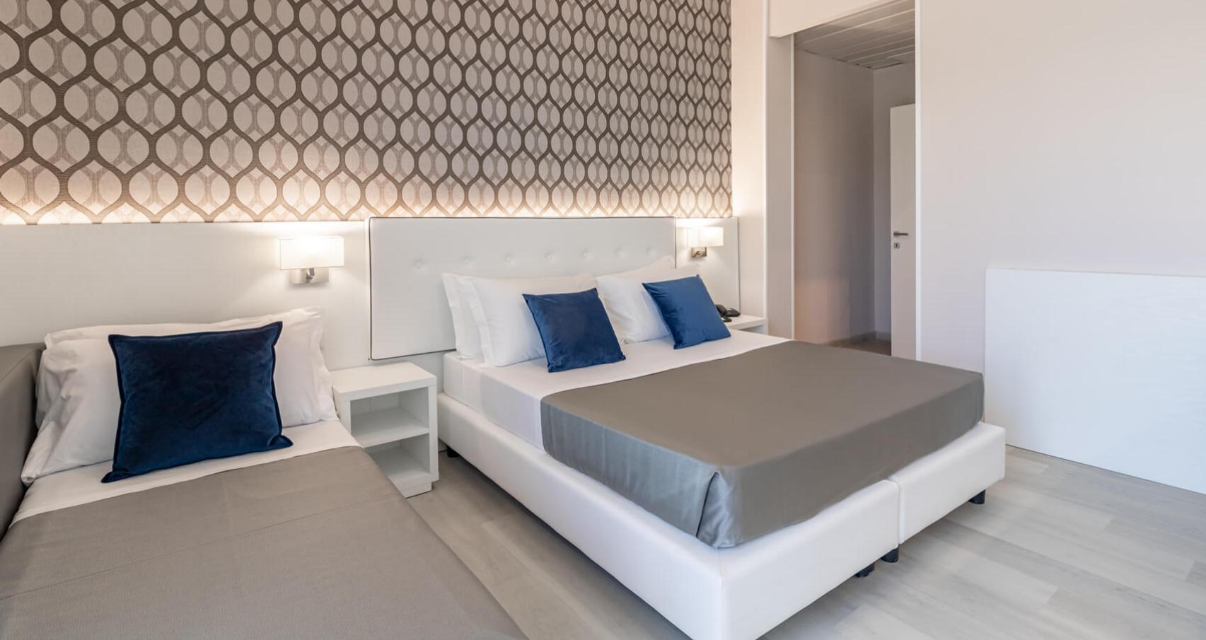 Modern room with double bed, TV, wardrobe, and balcony.
