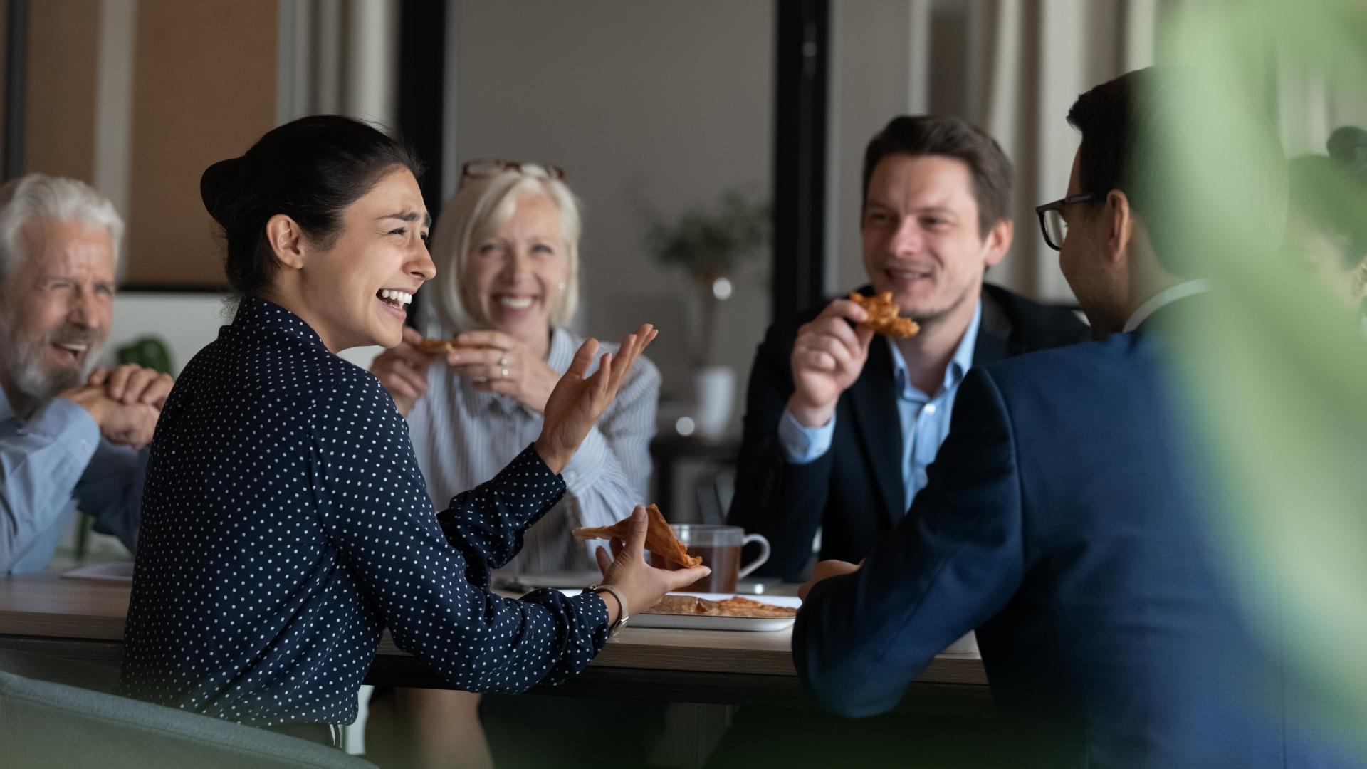 Smiling colleagues sharing a lunch break together in the office.