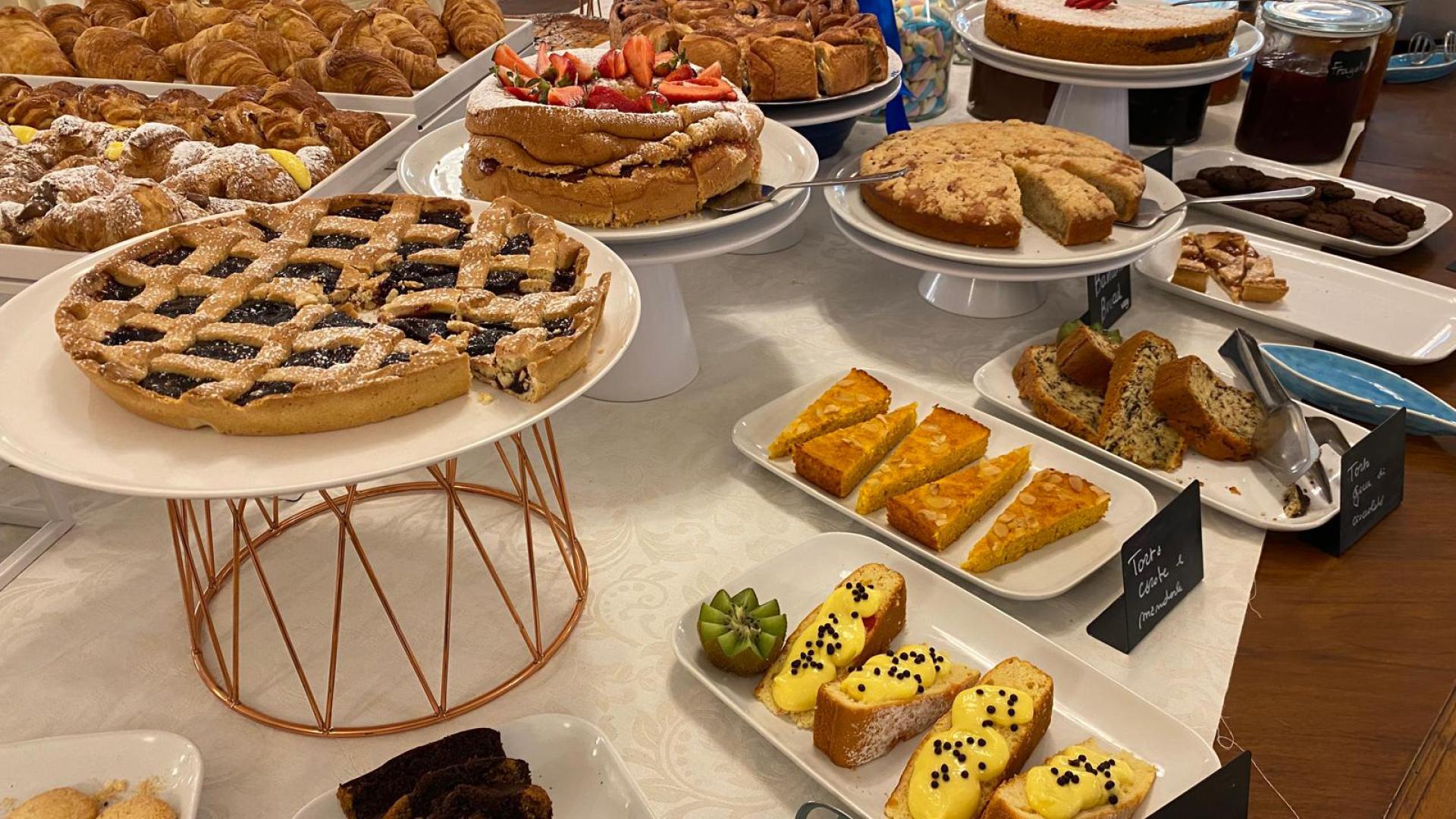 Un buffet di dolci assortiti con torte, crostate e pasticcini.