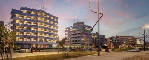 Vista serale di una città con moderni edifici e lampioni curvi.