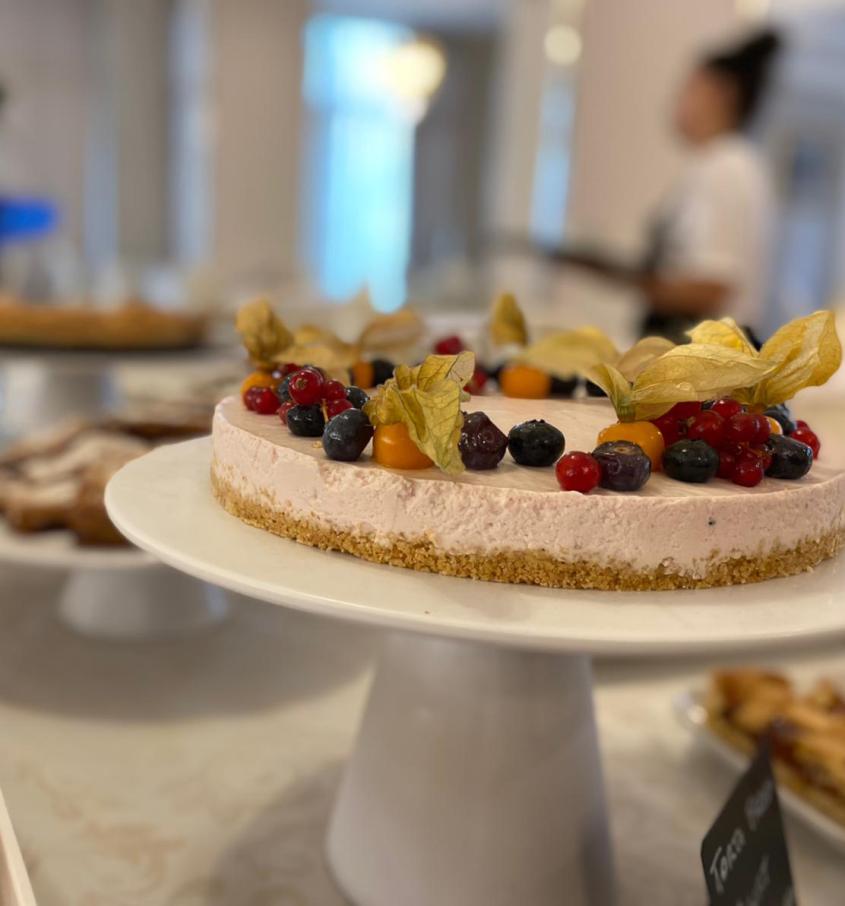 Torta con frutti di bosco e dolci vari su un tavolo da dessert.